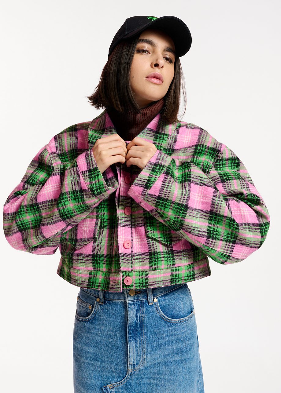 A woman wearing a pink and green plaid jacket.