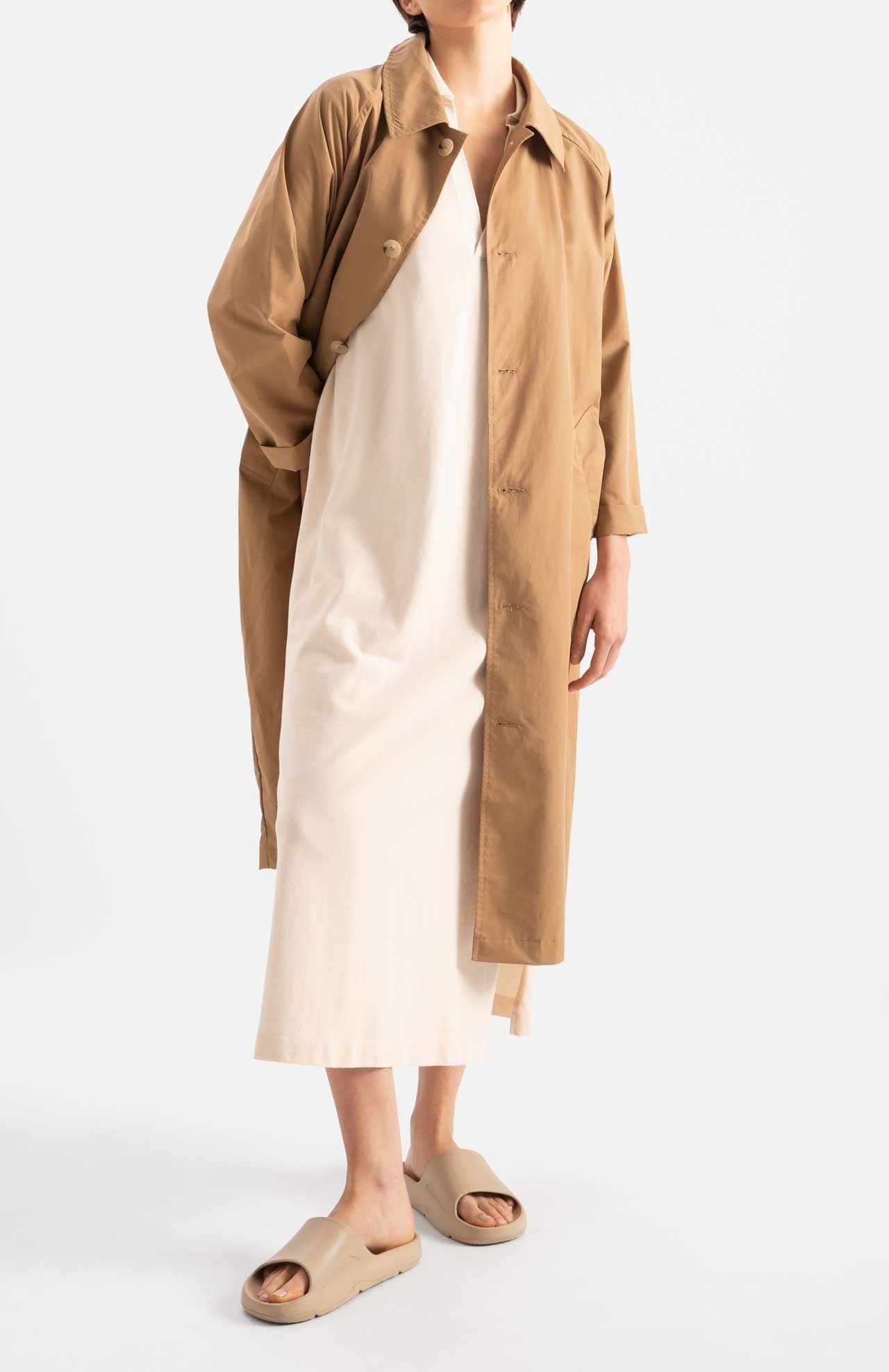 Model wears trench style coat in dark camel colour