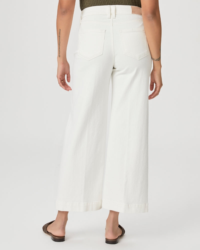 The back view of a woman in Paige Anessa Wide Leg - Light Ecru high-waisted white cropped pants.