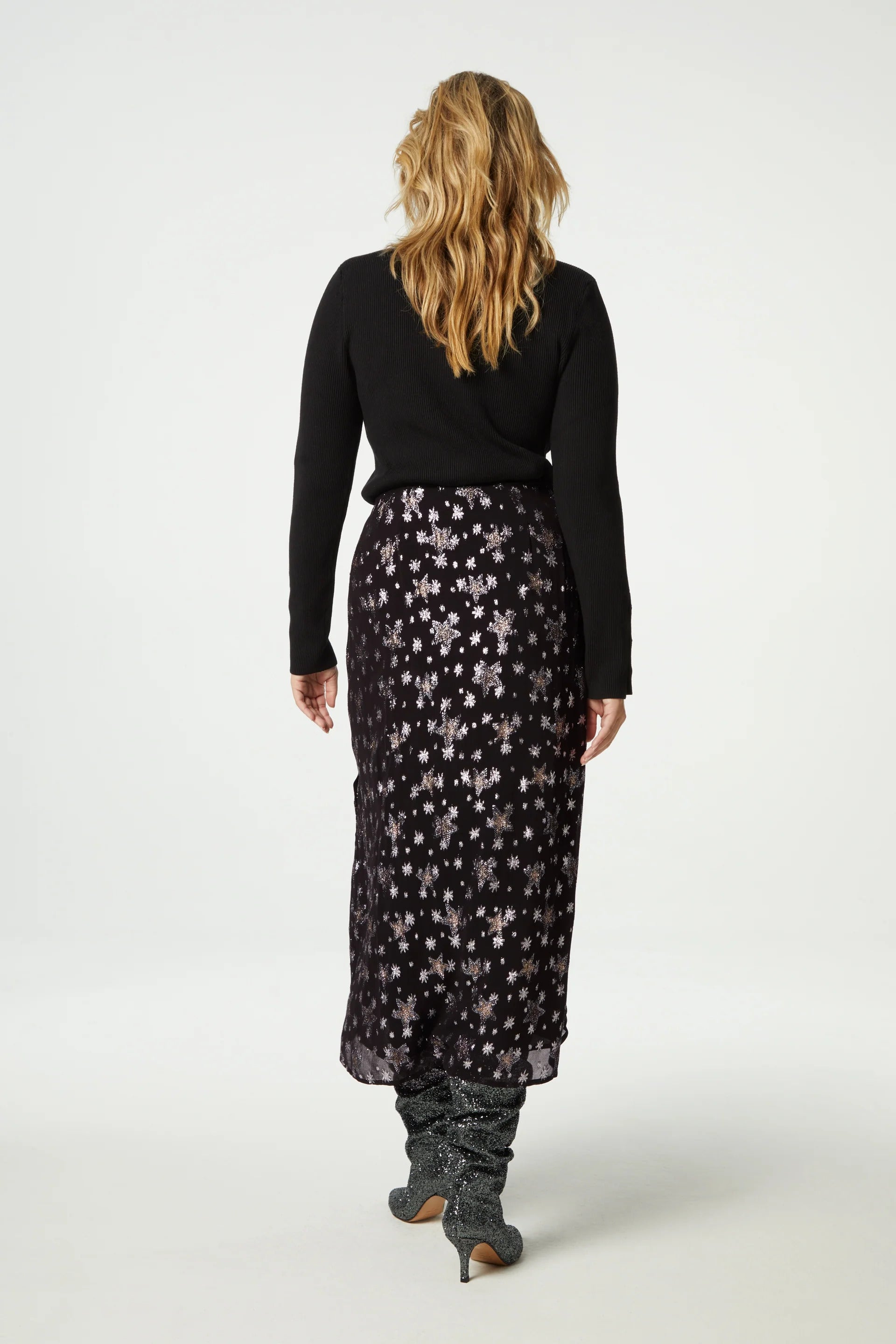 The back view of a woman wearing the Fabienne Chapot Lydia Skirt - Starfleet and black boots.