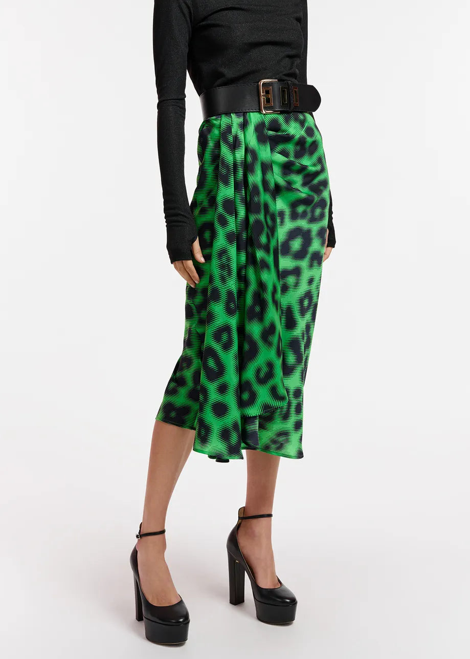 A woman wearing an Essentiel Antwerp Everest Skirt in Green, a green leopard print midi skirt made from recycled polyester-blend fabric.