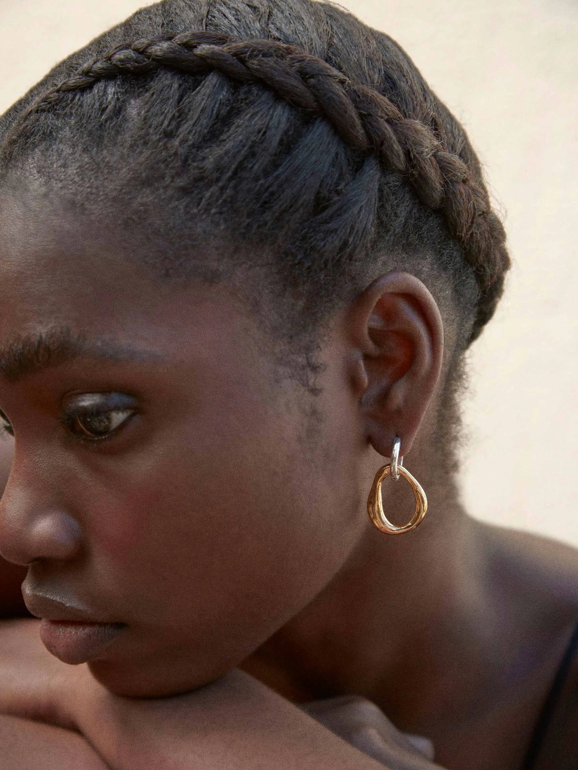 A black woman wearing a pair of SHYLA - Meridien Hoops - Gold earrings from Shyla.