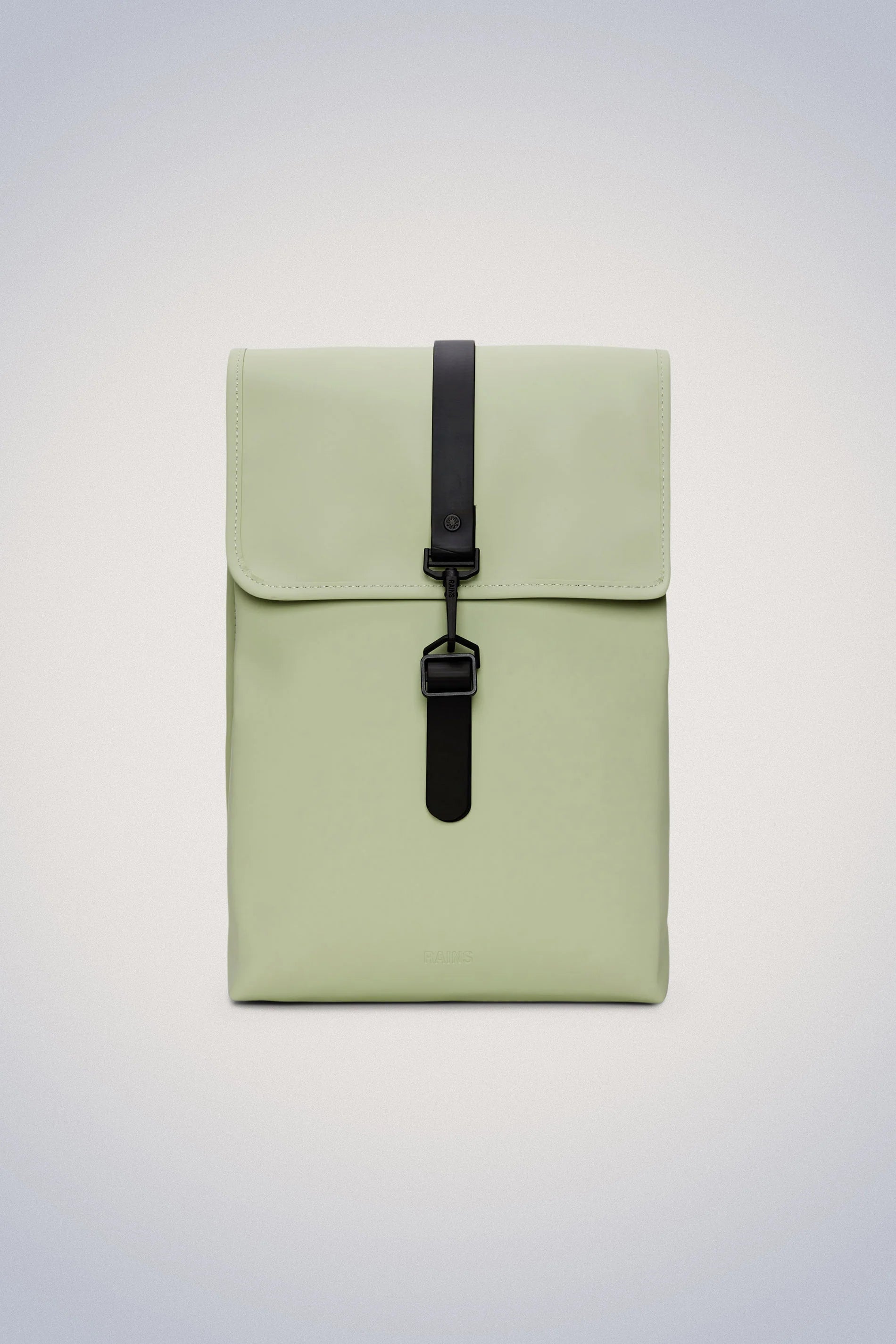 The Rains Rucksack is a small green backpack with black straps. This stylish Rains rucksack is made with durable waterproof fabric, making it perfect for daily commutes or weekend adventures.