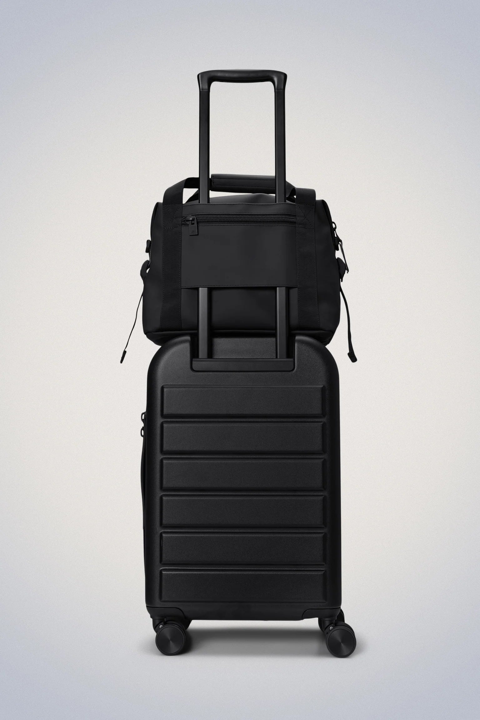 A Rains Texel Kit Bag, a black travel bag with wheels on a white background.