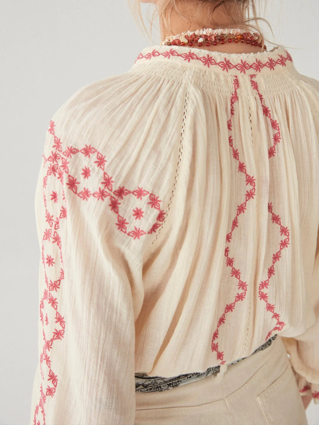 model wears off-white and pink embroidered blouse