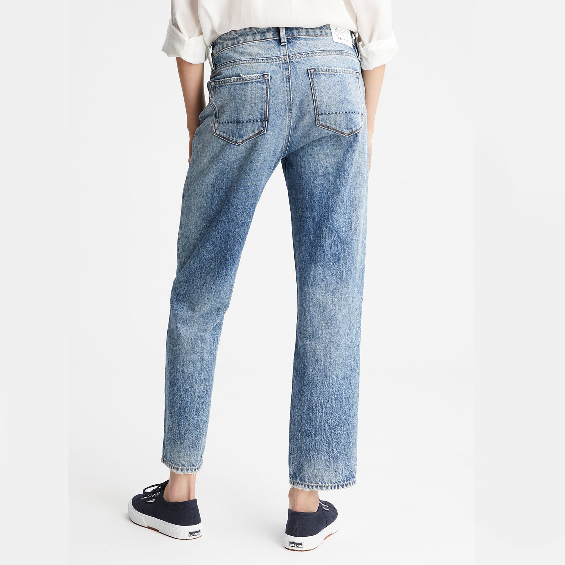 The back view of a woman wearing a pair of Denham BARDOT Straight Leg - Stonewash Blue jeans, made from organic cotton using a sustainable process.