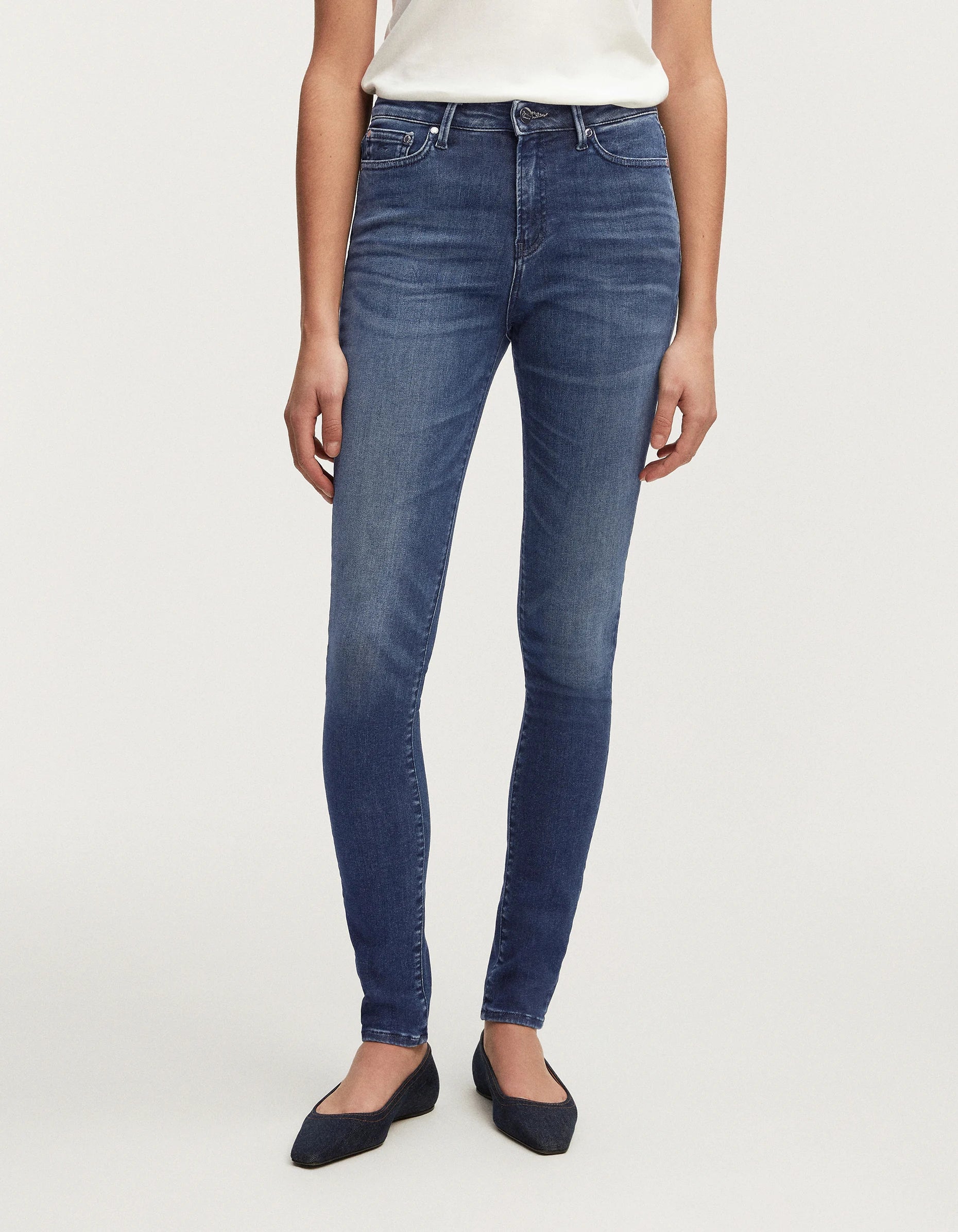A woman wearing a pair of Denham NEEDLE Skinny - Dark Soft Wash high-rise jeans from the 70s.