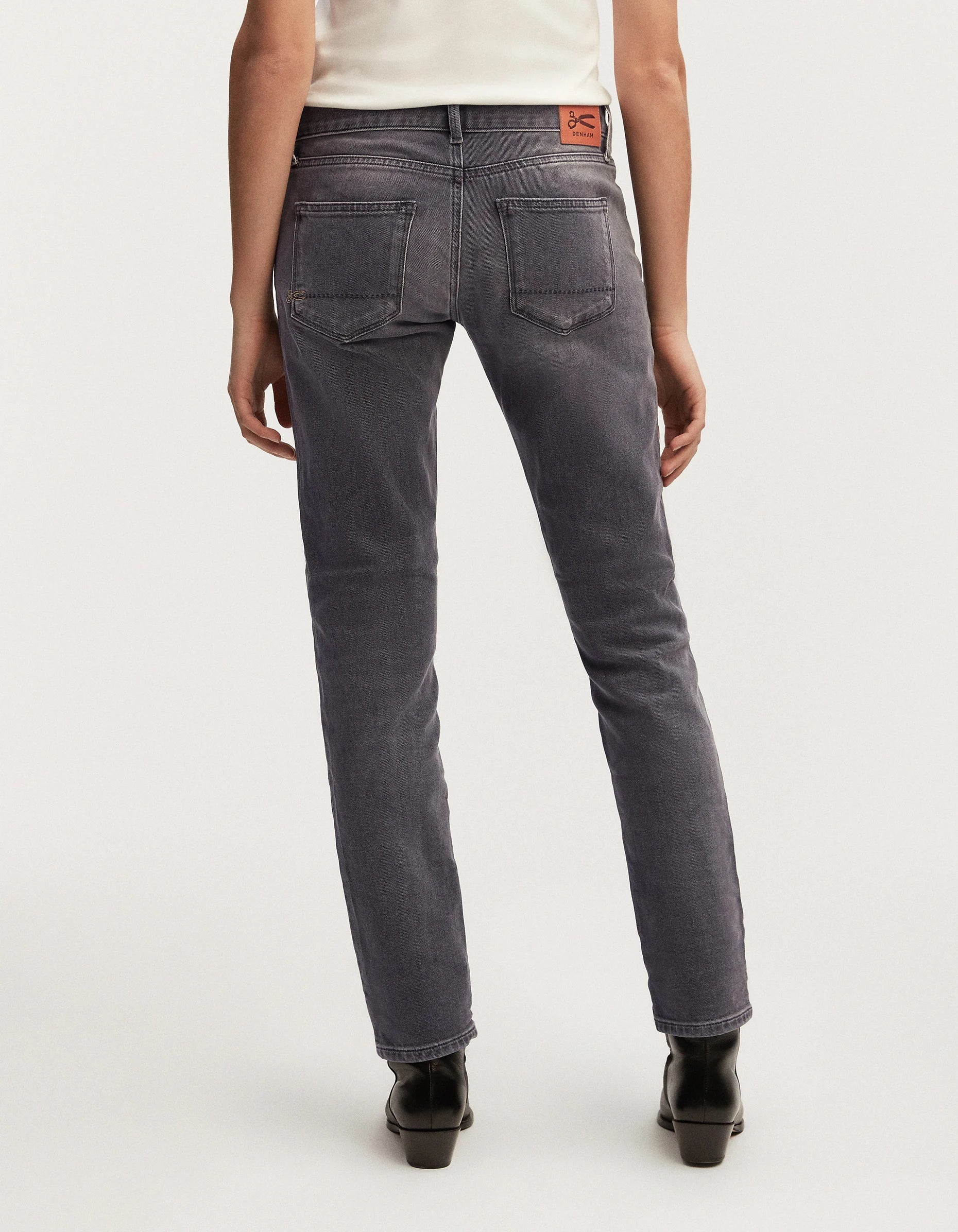 The back view of a woman wearing MONROE - Authentic Grey Wash mid-rise cut jeans from Denham's Authentics range.