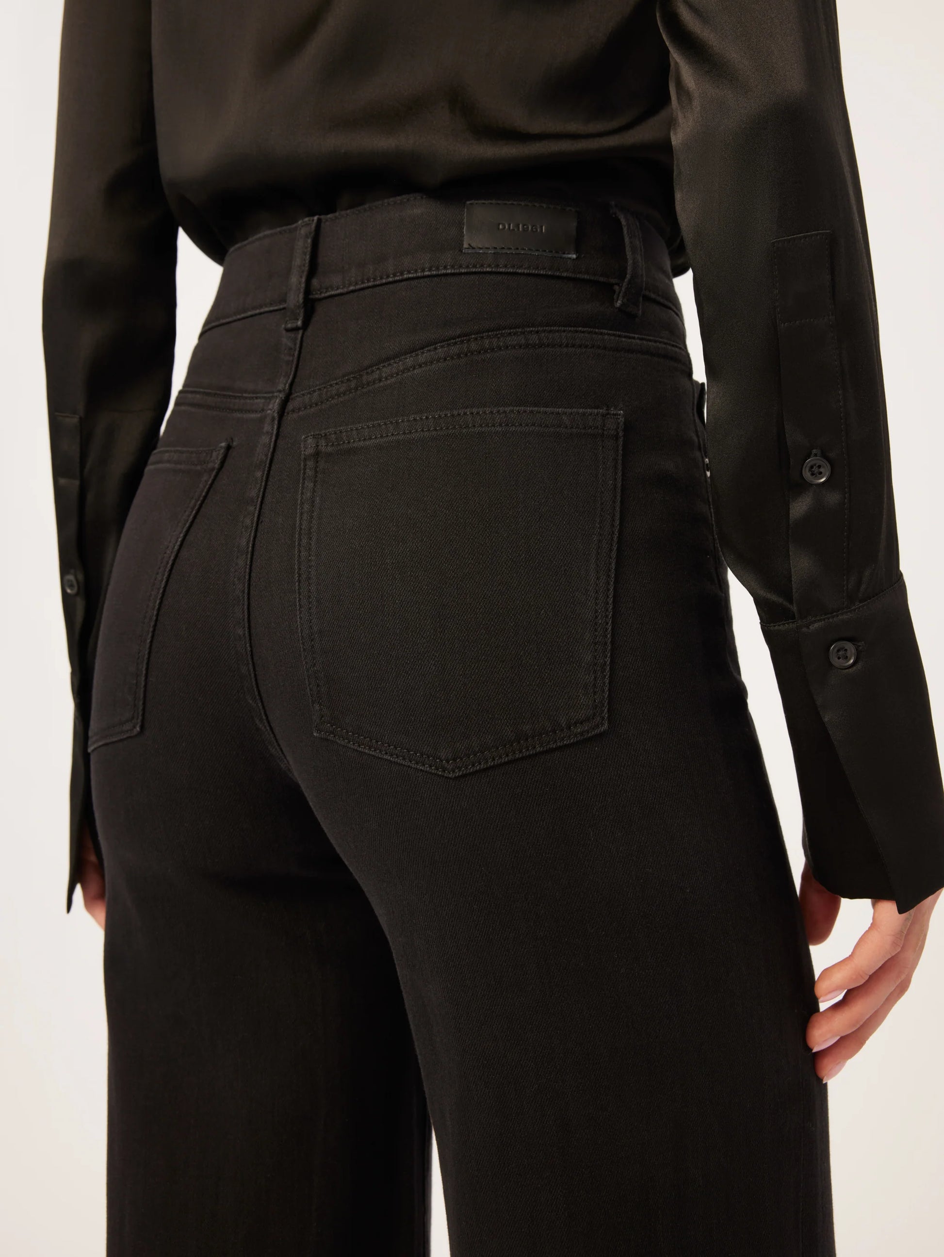 The back view of a woman in DL1961 Hepburn Wide Leg - Jet Black jeans.