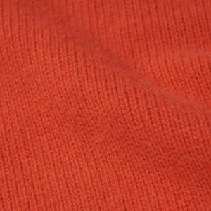 A close up of the wool material of the Isla W jumper in shade orange.