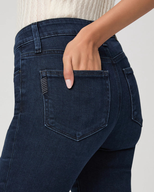 A person wearing Paige's Gemma Cigarette Leg - Bespoke jeans, shown from the waist down with one hand in the back pocket.