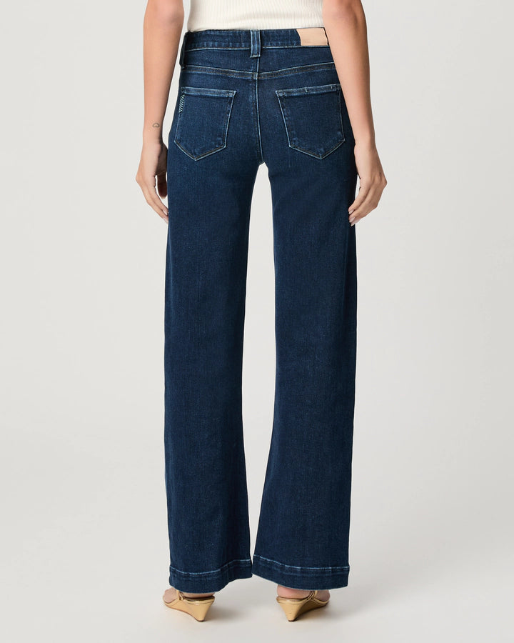 Wearing the Paige Leenah Slim Wide Leg jeans in the vintage Basilica wash with beige heels, shown from the back against a plain light background.