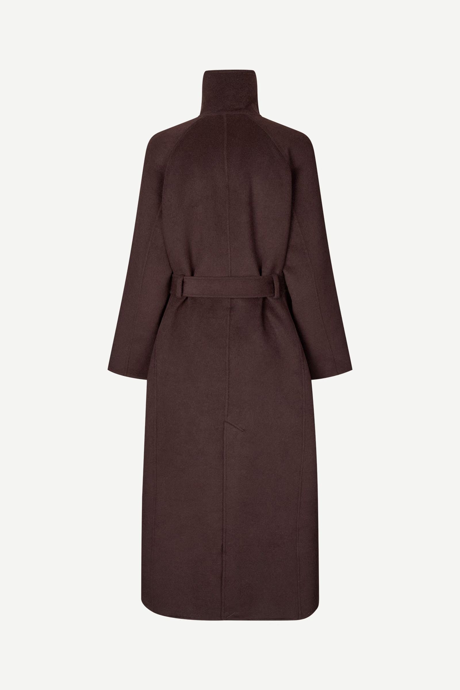 The Sahanne Coat by Samsøe Samsøe in Black Coffee is a long, dark brown felted wool coat with a high collar, long sleeves, and a matching waist belt. Featuring an oversized fit, it is shown from the back against a plain white background.