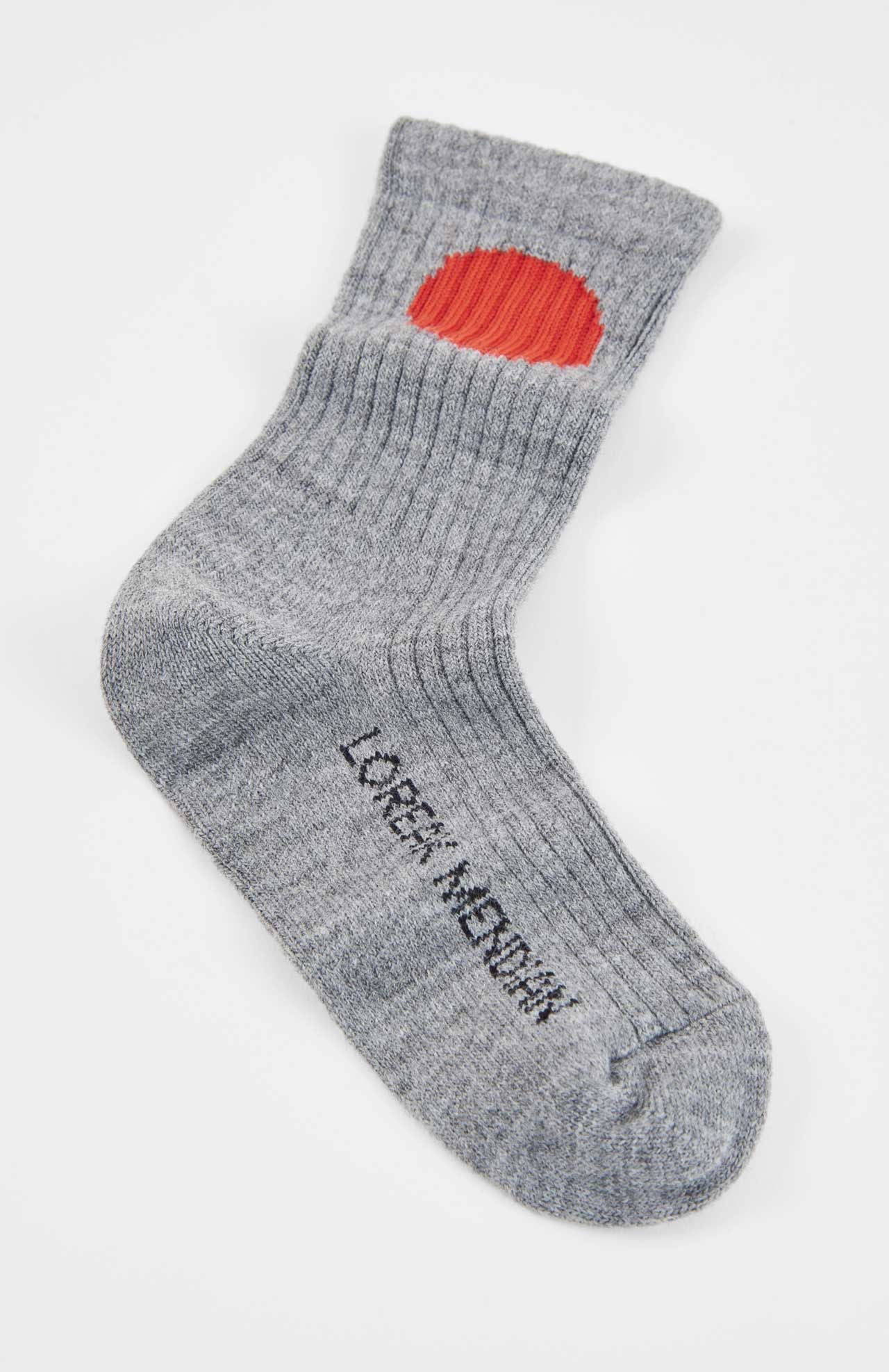 A single gray Bioti Mid-Calf Sock by Loreak Mendian, featuring a red oval patch near the cuff and “L/GEN. MEDIUM” printed in black on the foot.