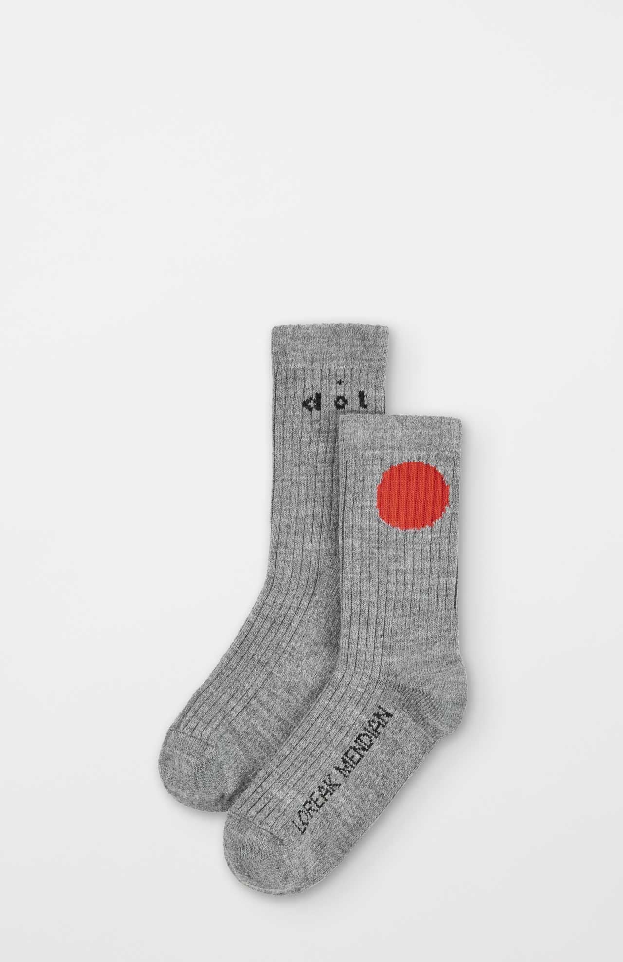 The Bioti Mid-Calf Socks by Loreak Mendian are gray, ribbed, and sustainable, featuring a large red circle and "Loreak Mendian" text near the toes for distinctive comfort and style.