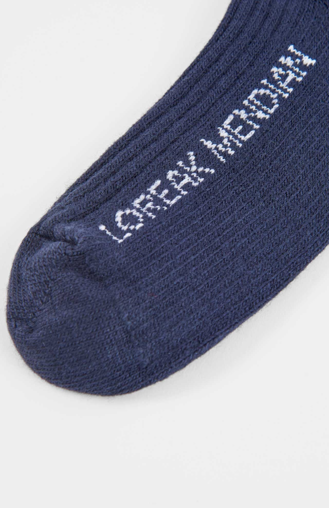 Close-up of the toe and part of Loreak Mendian's Bioti Mid-Calf Socks in navy blue ribbed fabric, with "LATERAL MEDIAL" embroidered in white.