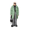 person wears the matt light green long padded puffer by rains over silver trousers and carries the texel carry bag 