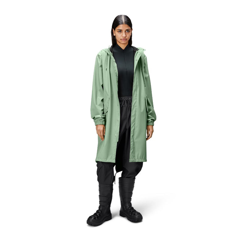 person is wearing a long matte green fishtail parka over black clothing