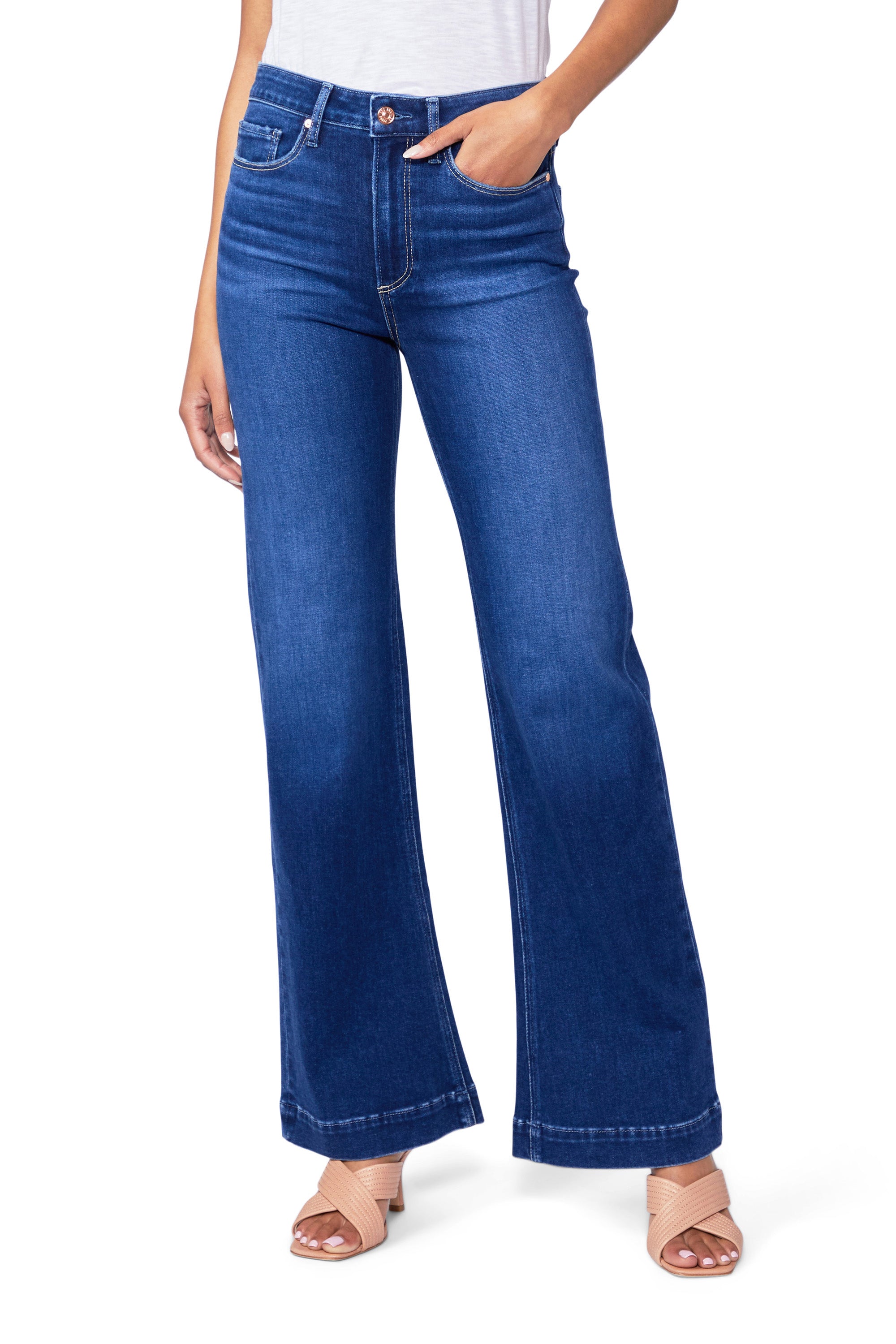 A woman is wearing a pair of high-waisted flared jeans, the Leenah Slim Wide Leg - Notre Dame by Paige, made with TRANSCEND denim.