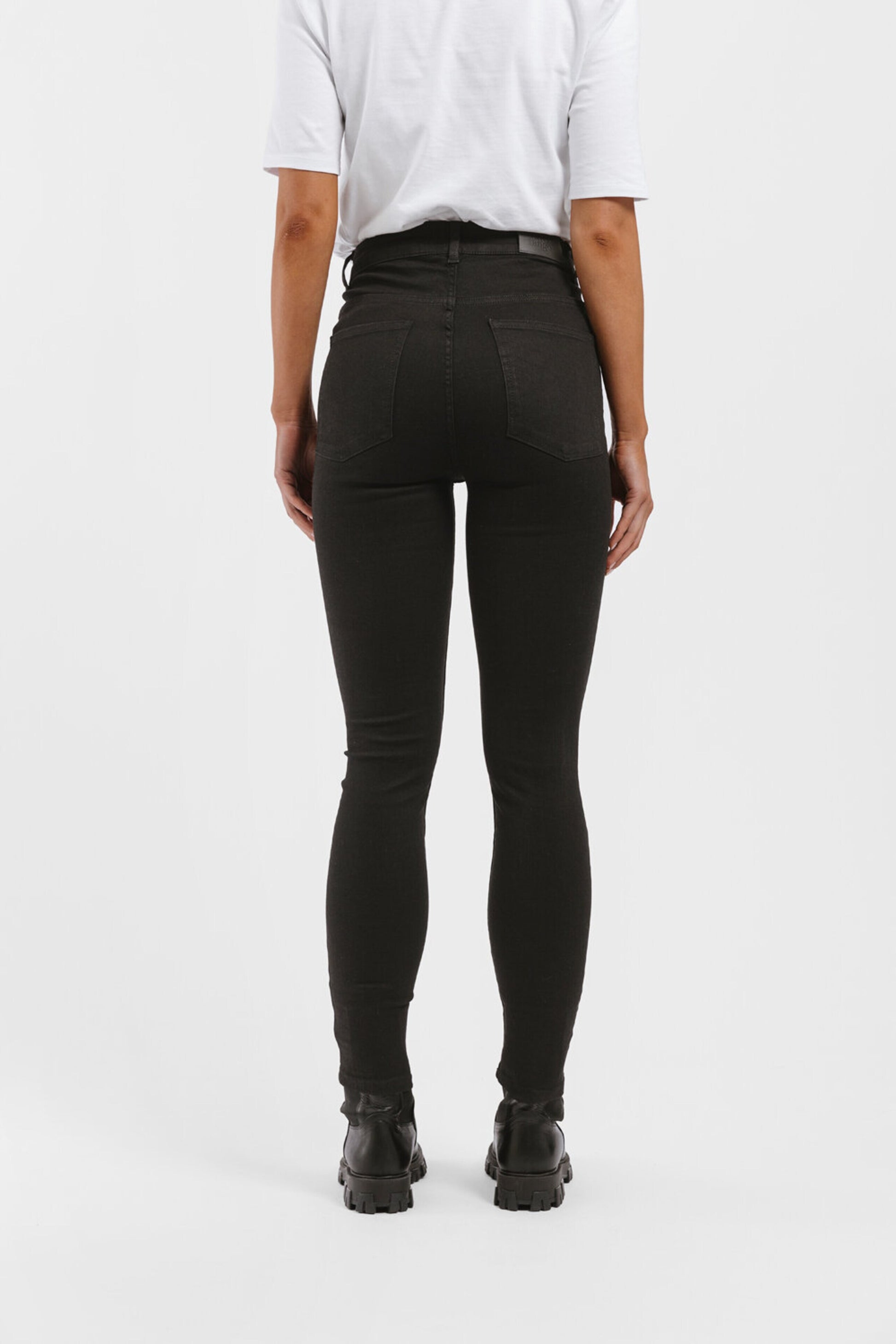The back view of a woman wearing Twist & Tango's Julie High Waist Skinny Jeans - Black.