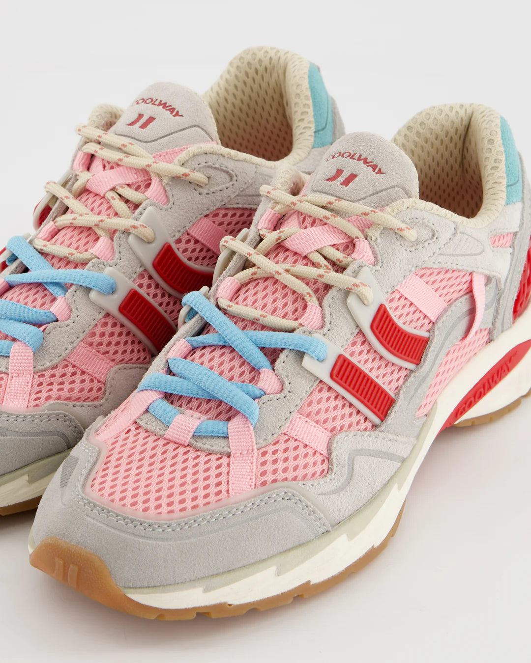 A pair of Coolway 2003 Sneakers - Pink Volt, featuring pink mesh, grey suede leather, blue and beige laces, red accents, and light blue heel details are displayed on a white background.