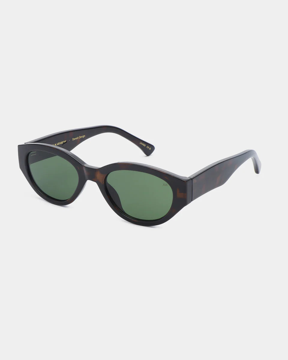 The Winnie Sunglasses - Demi Tortoise by A. Kjærbede are Scandinavian cat-eye sunglasses with green-tinted lenses, made from recycled materials and shown on a white background.
