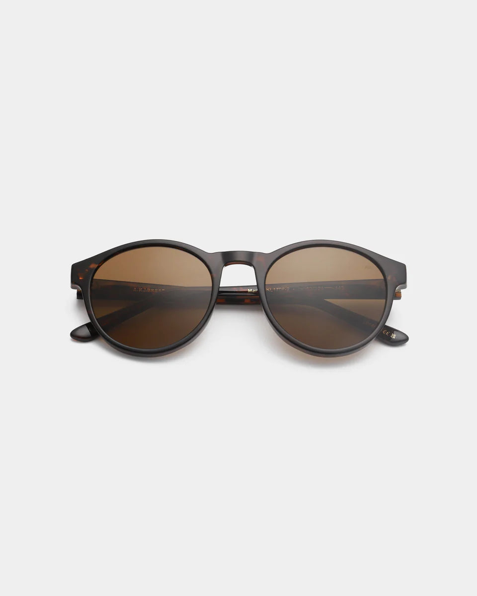 The Marvin Sunglasses - Demi Tortoise by A. Kjærbede are round unisex frames in dark brown tortoiseshell with brown tinted lenses, crafted from recycled materials and shown on a plain white background.