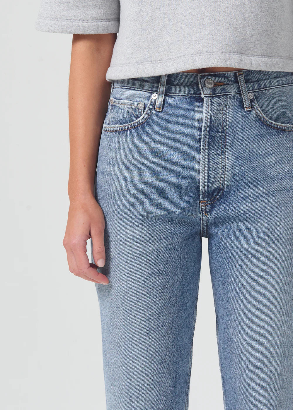 The back view of a woman wearing AGOLDE 90's Pinch Waist - Navigate high-rise waist jeans made with organic cotton.