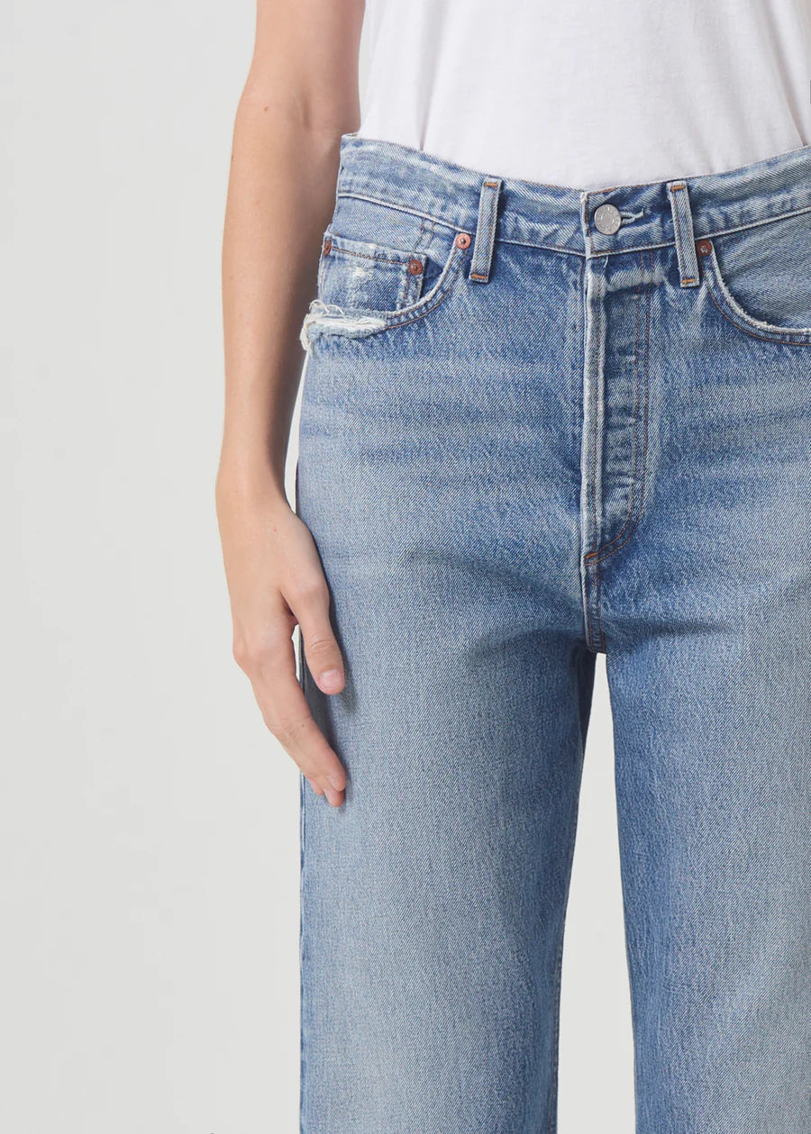 Model wears 90s style straight jeans in light blue.