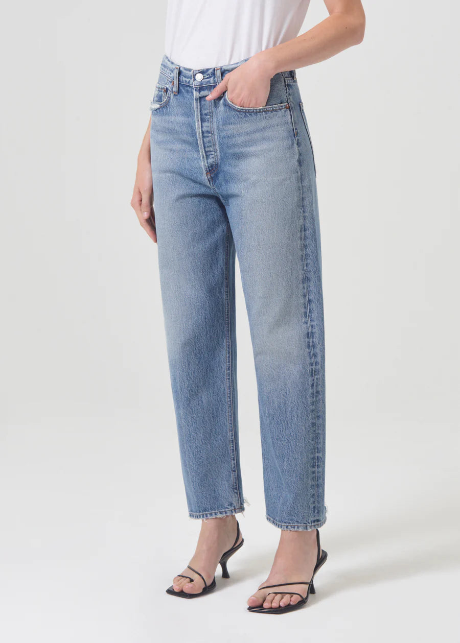 Model wears 90s style straight jeans in light blue.