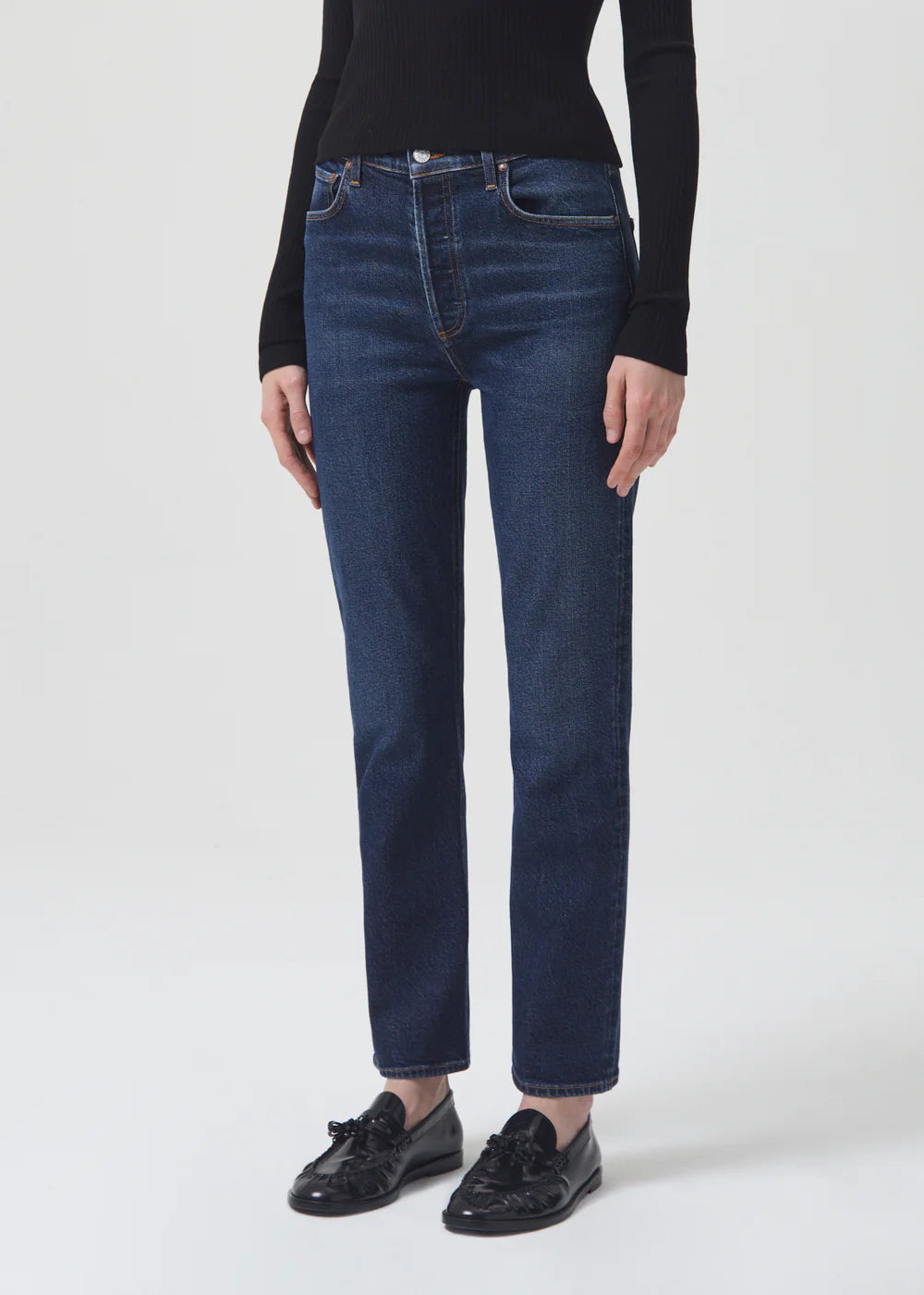 The model is wearing AGOLDE Riley Straight Long - Divided jeans and a black sweater.