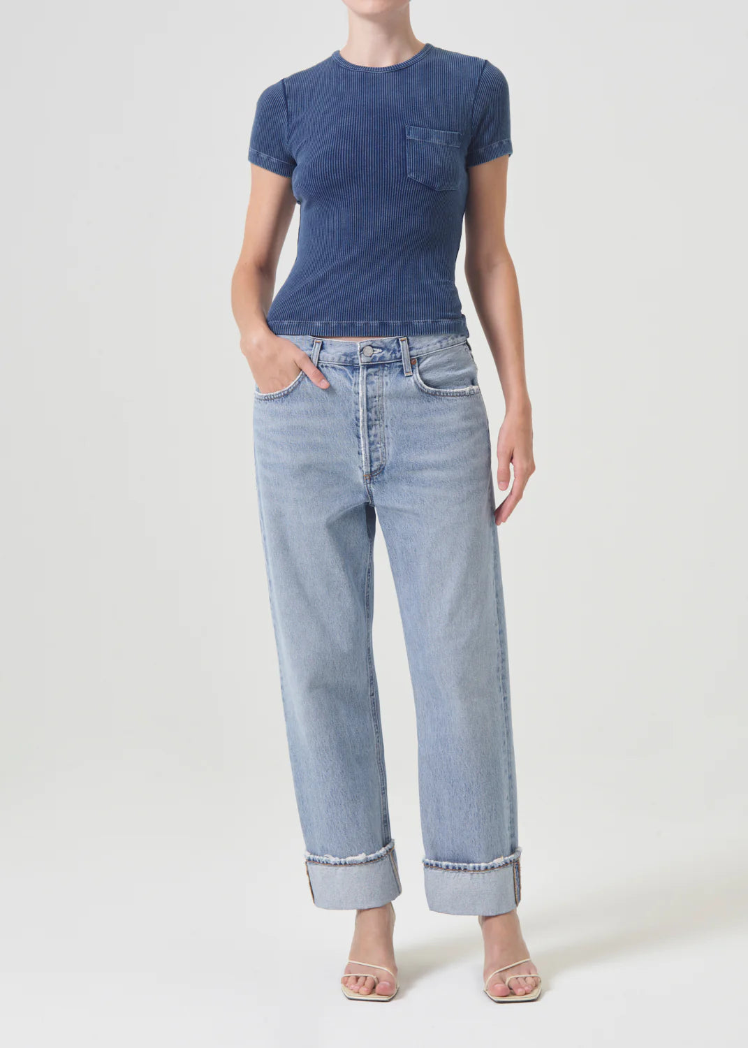 The model is wearing AGOLDE Fran Low Slung Straight - Force jeans and a retro-inspired blue t-shirt.