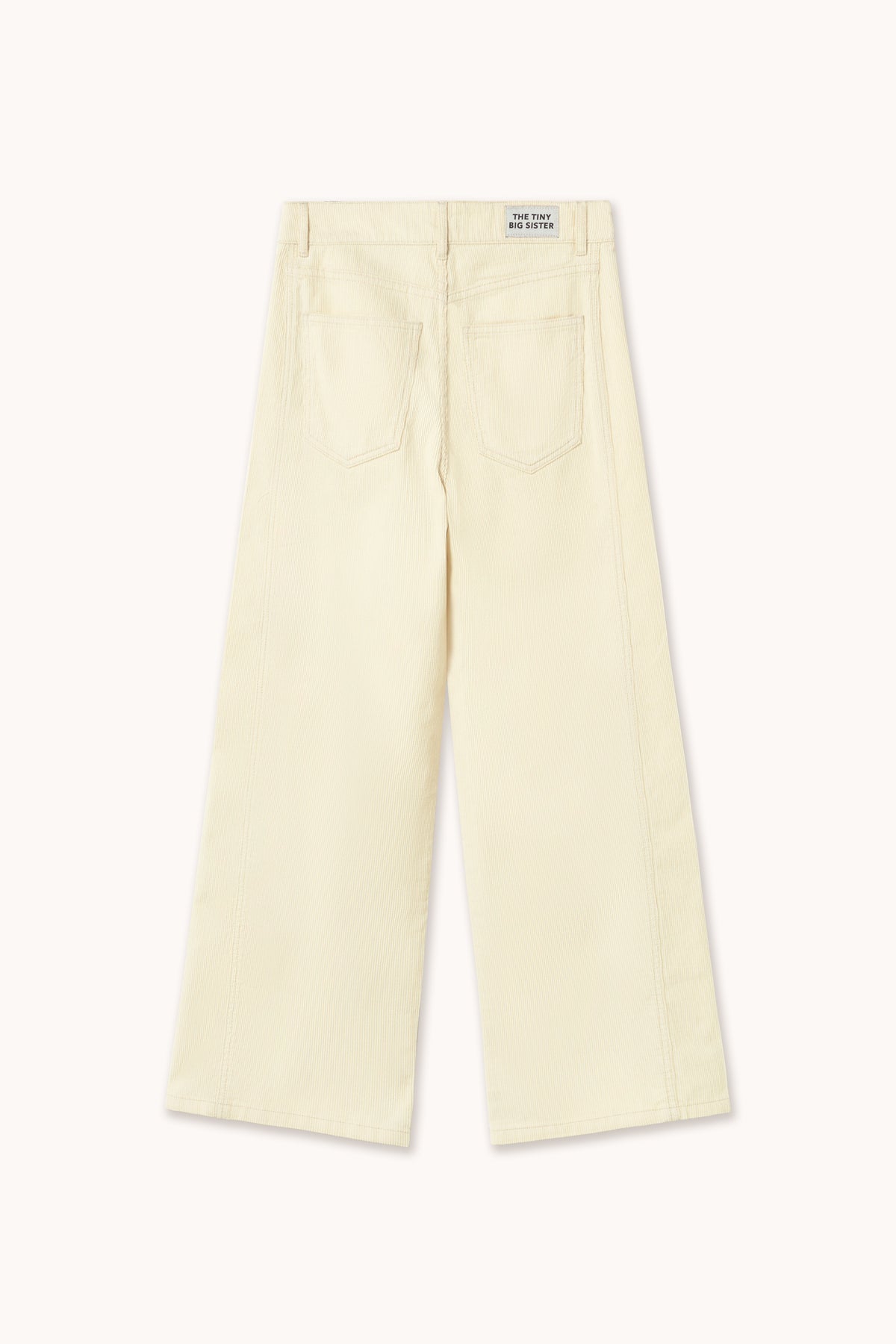A pair of light cream-colored wide-leg cropped pants shown from the back, featuring a small white brand label at the back waistband, set against a solid off-white background.