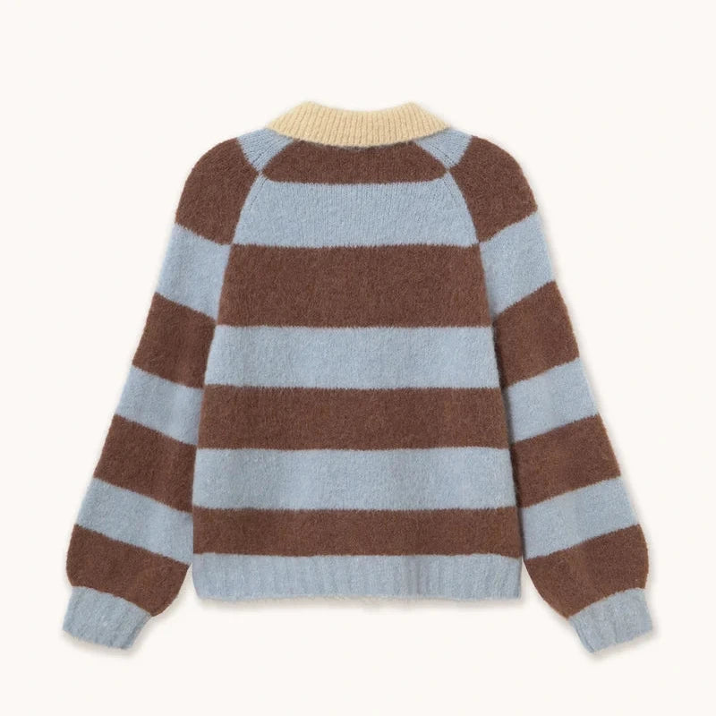 The Frank Striped Polo - Washed Blue by Tiny Big Sister is a fuzzy sweater with a relaxed silhouette and wide horizontal brown and light blue stripes, featuring a cream ribbed neckline along with ribbed cuffs and hem, displayed laid flat on a light background.
