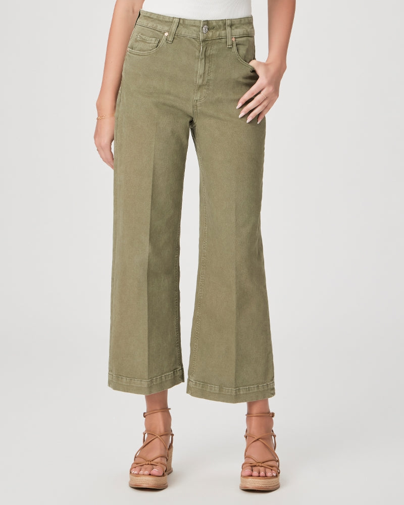 Model wears wide leg ankle length jeans in moss green shade