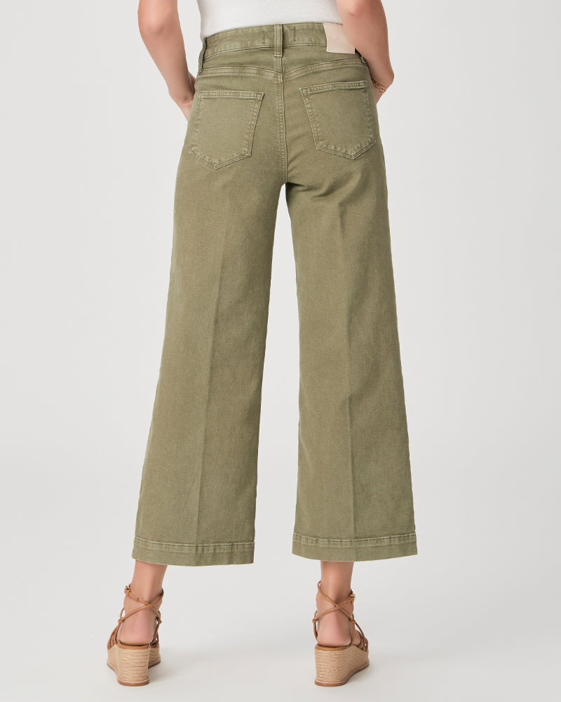 Model wears wide leg ankle length jeans in moss green shade