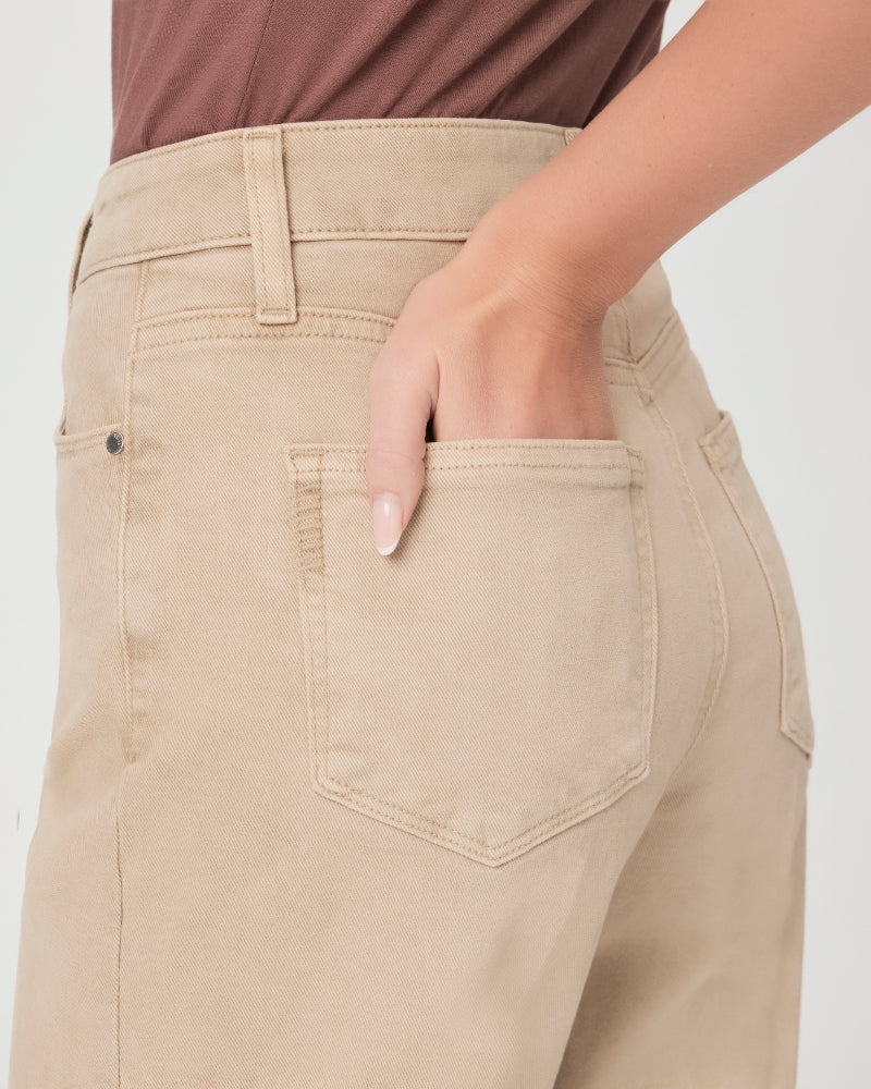 A person's hand tucking into the back pocket of Paige's Anessa Wide Leg - Vintage Soft Sand trousers.