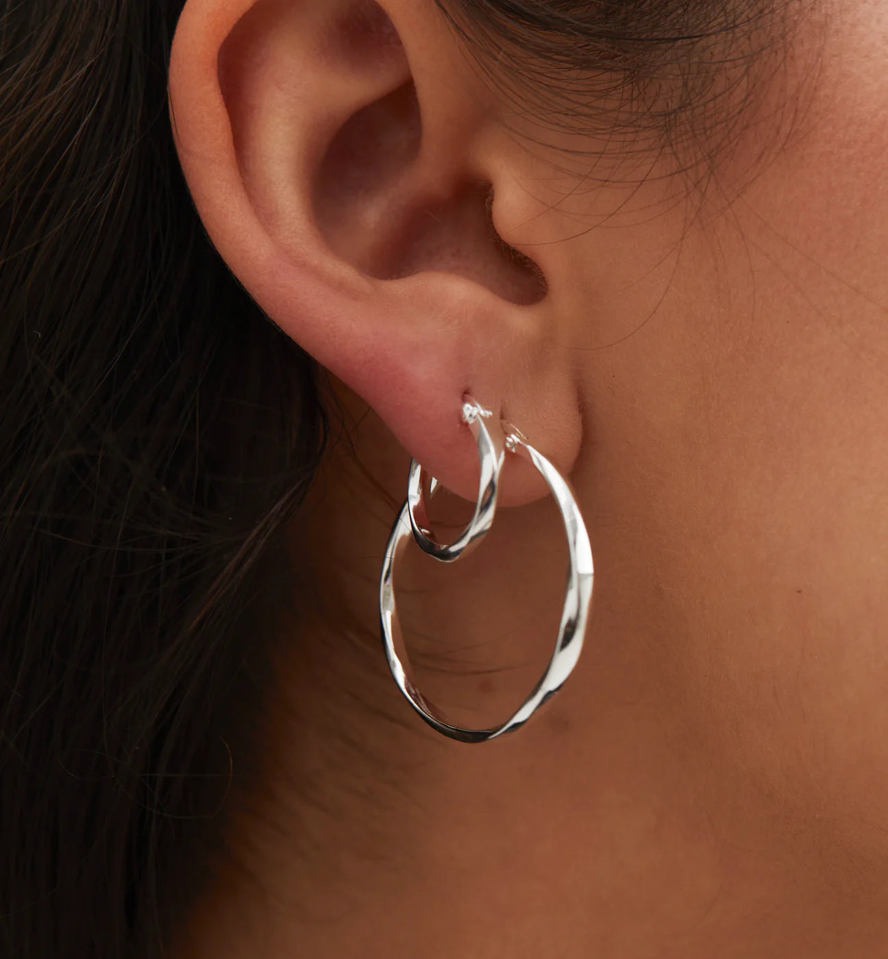 model wearing silver hoop earrings