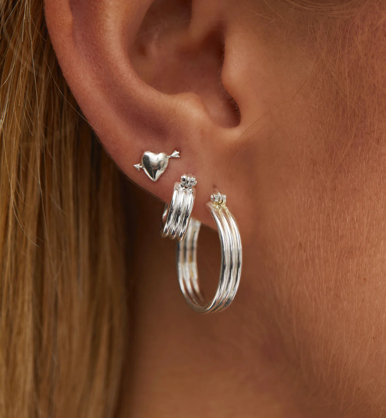 model wears small ring earrings in silver