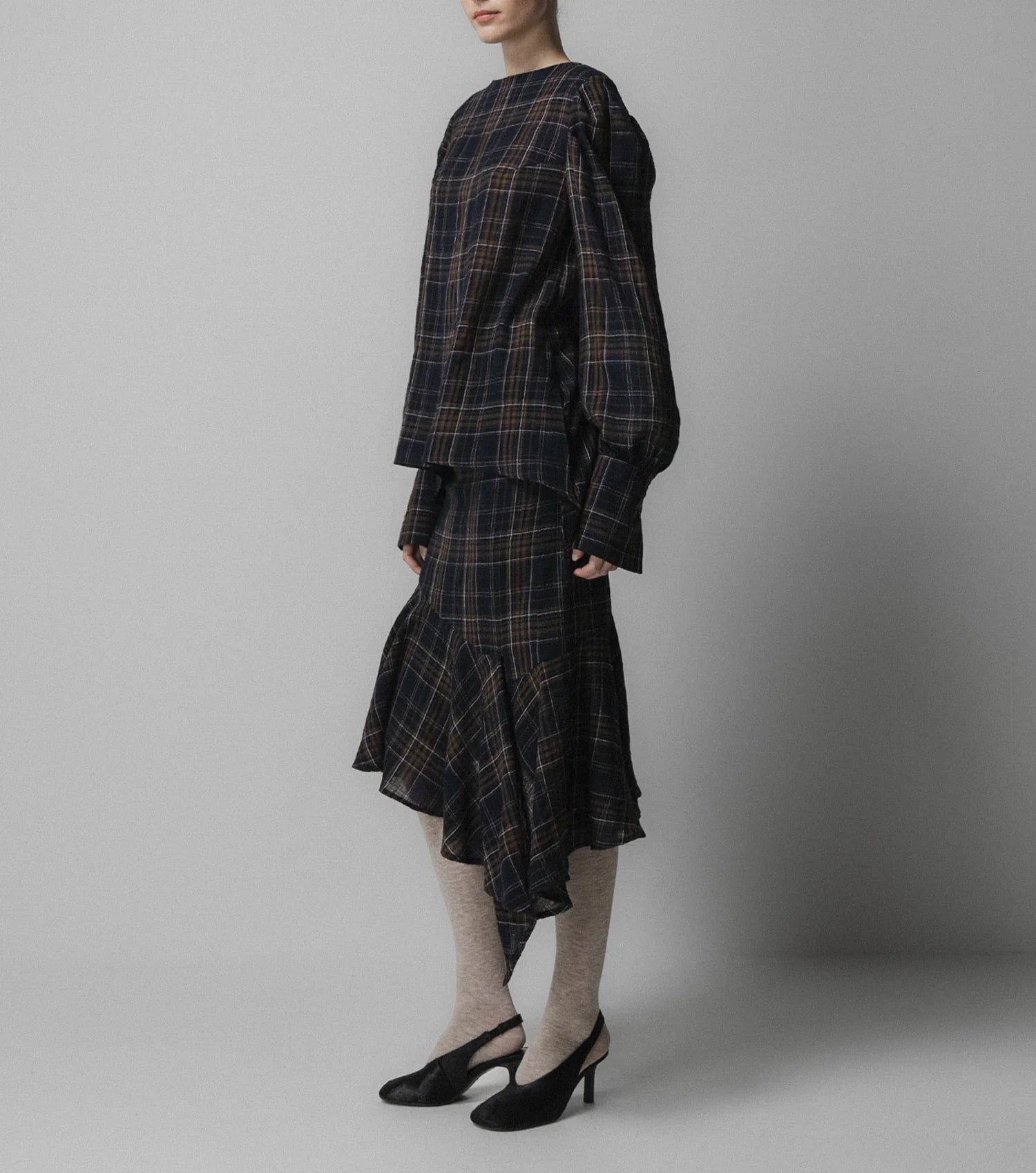 A woman wearing the Emin and Paul Volume Sleeve Blouse in navy check.