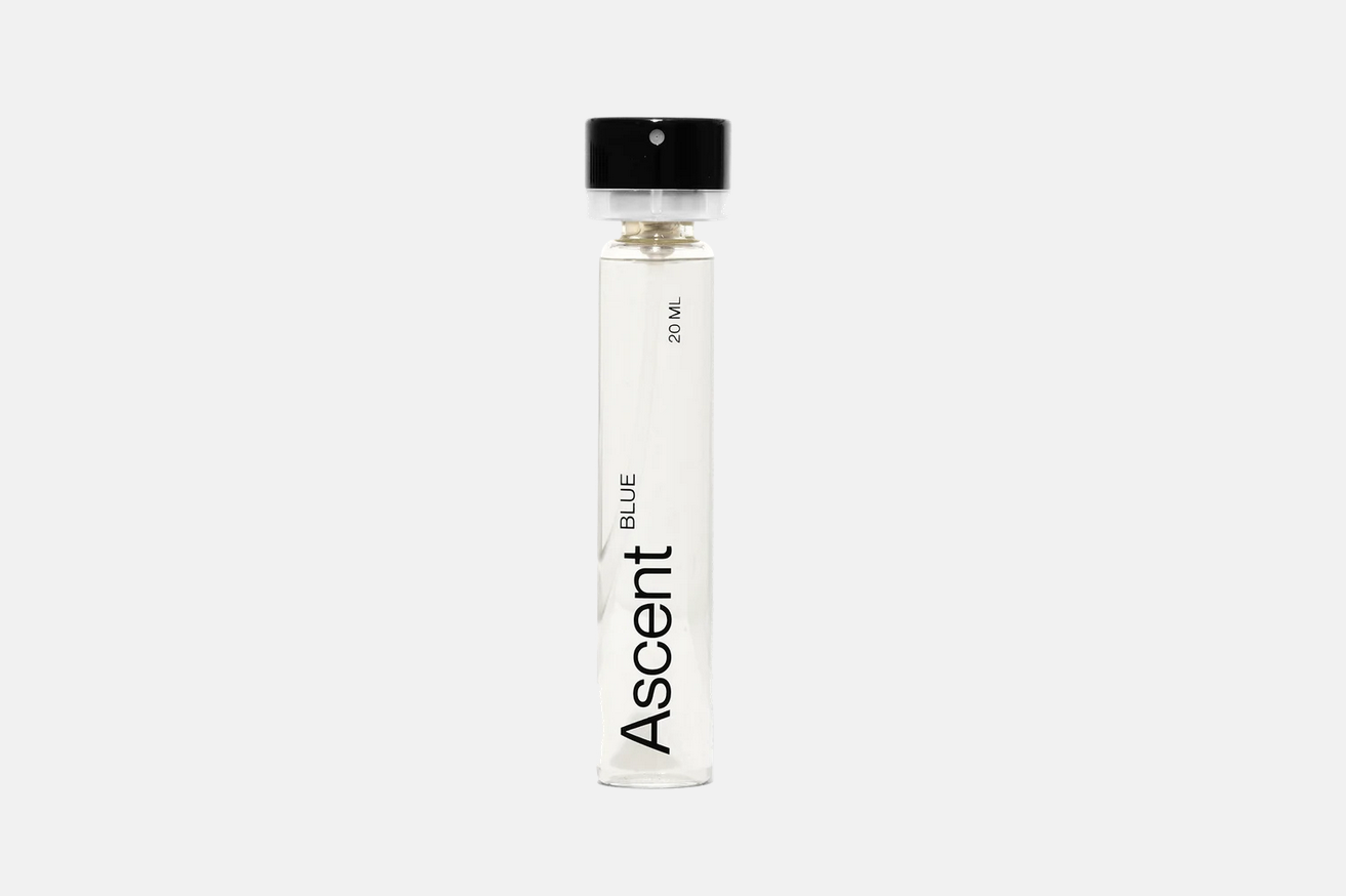 A cylindrical glass vial of Ascent Refillable Perfume - Blue with a black cap, labeled “20 ML” and “BLUE”.