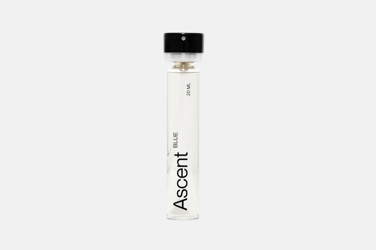 A cylindrical glass vial of Ascent Refillable Perfume - Blue with a black cap, labeled “20 ML” and “BLUE”.