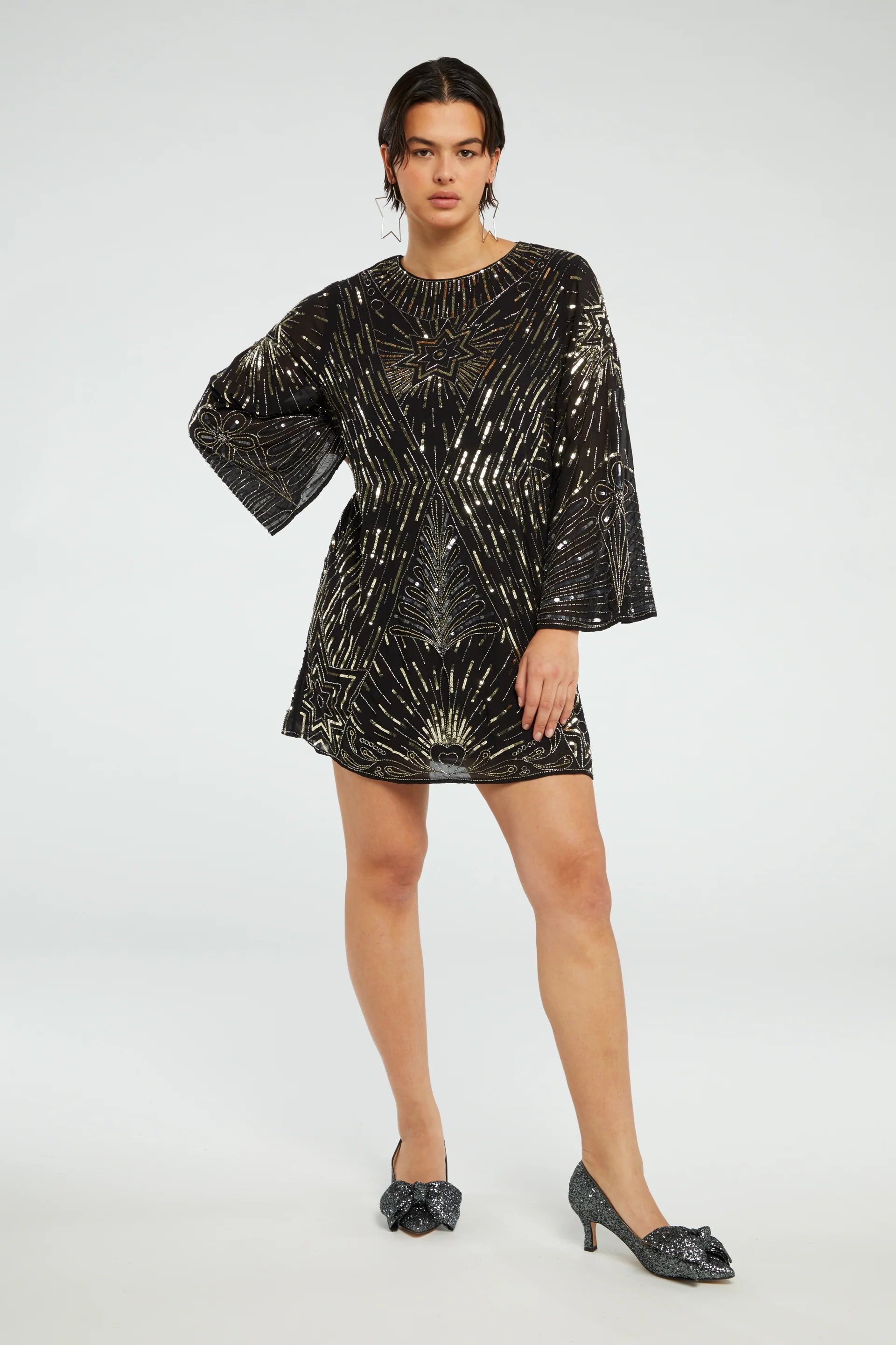 The model is wearing a Zali Dress - Black by Fabienne Chapot with gold sequin details.