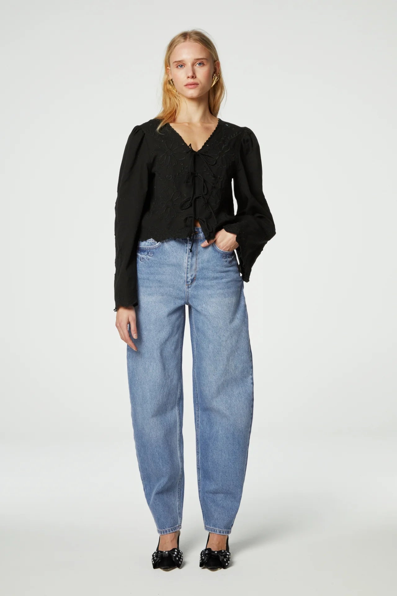 The model is wearing high waisted jeans and a Sterre Top in black by Fabienne Chapot for a feminine look.