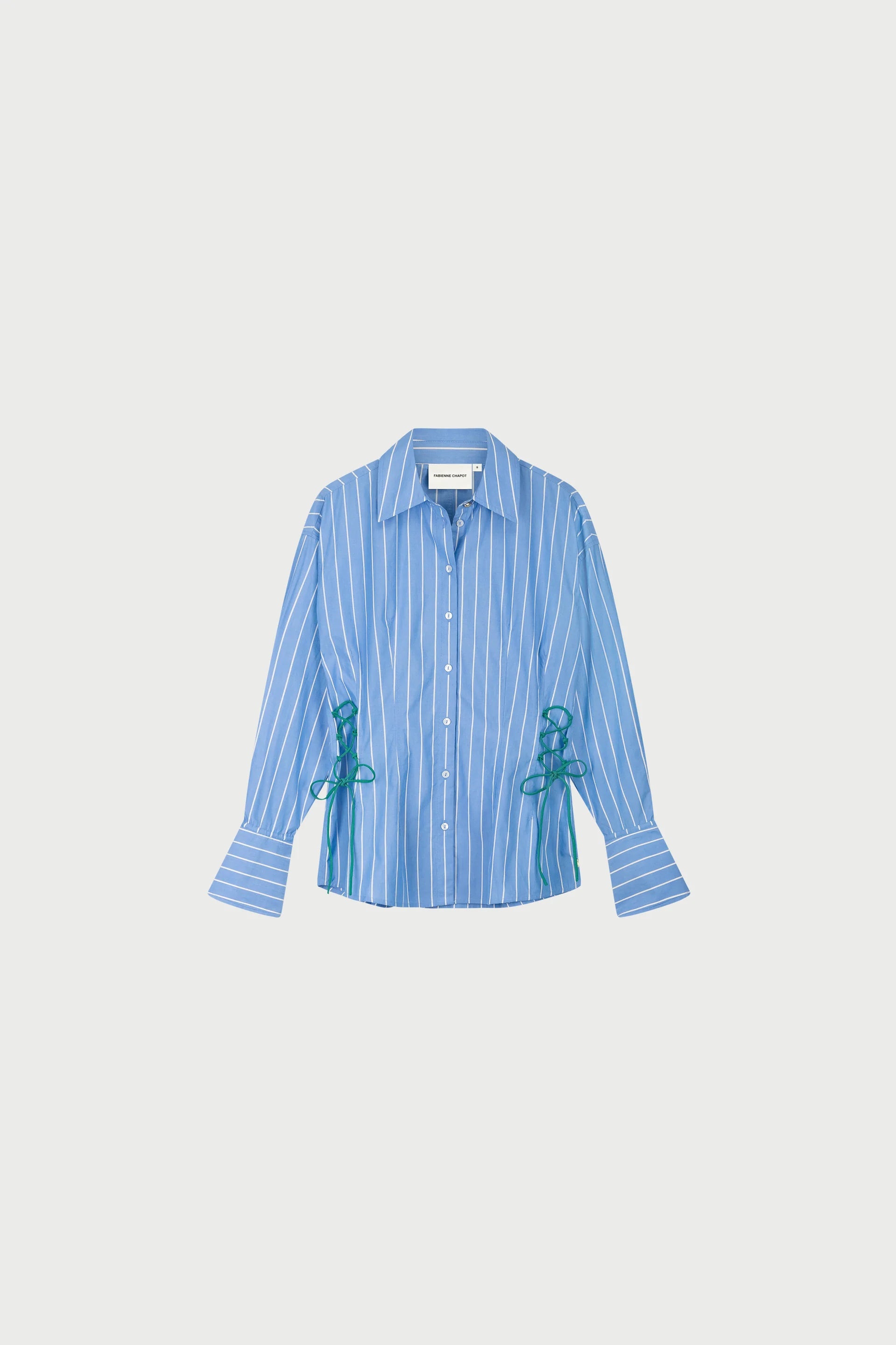The Indra Blouse - Marine Blue by Fabienne Chapot features blue and white stripes, long sleeves with wide cuffs, green ribbon ties at the sides, subtle green lace detail, and is crafted from organic cotton for comfort.