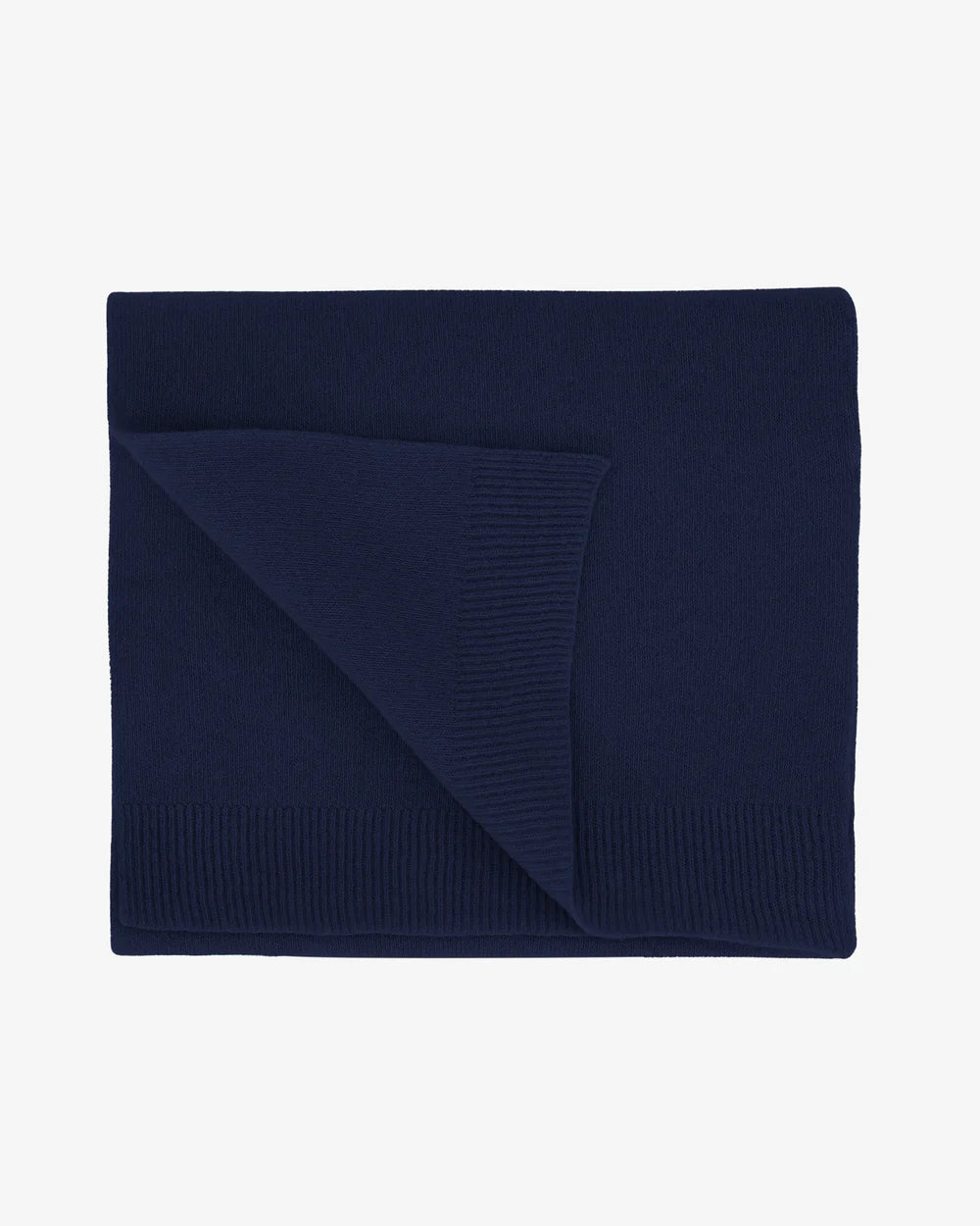 The Colorful Standard Merino Wool Scarf, crafted from recycled merino wool with ribbed edges in navy blue, is neatly folded and displayed on a plain white background.