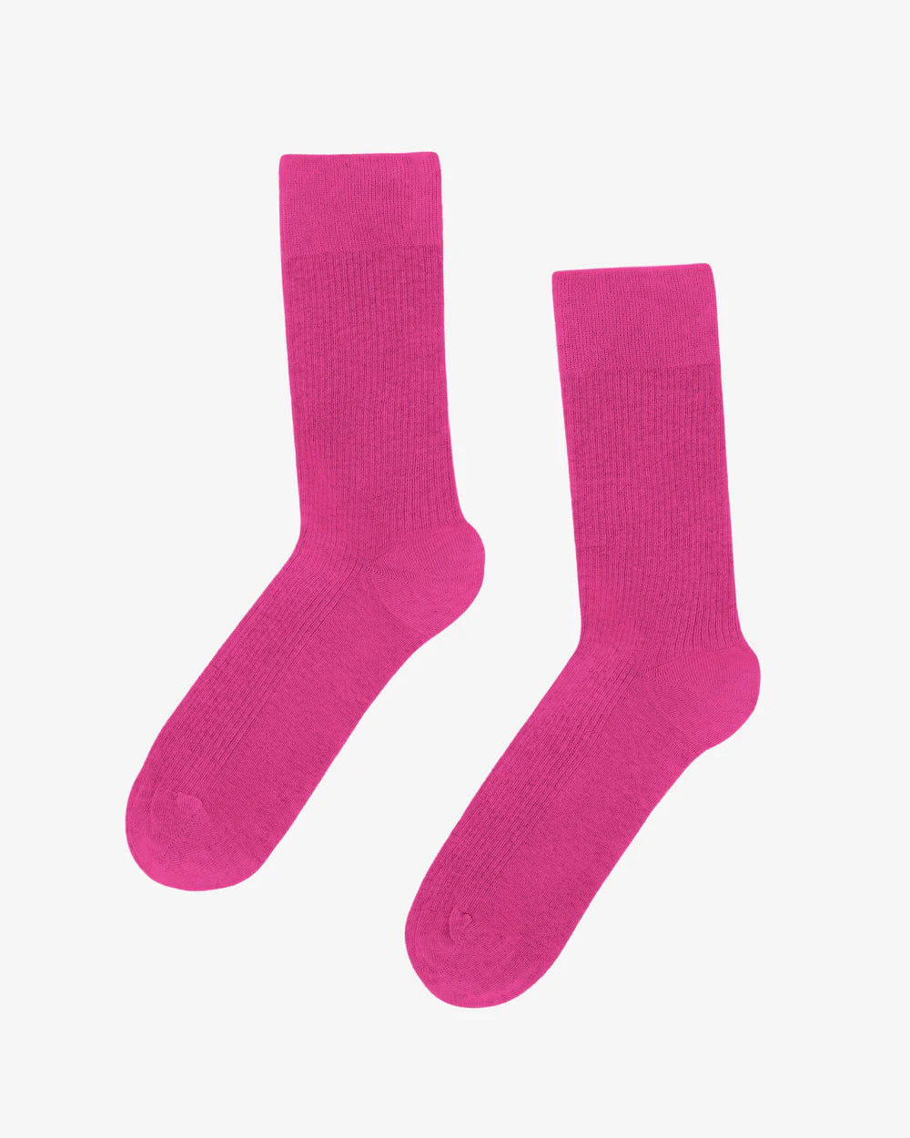 The vibrant Organic Active Sock by Colorful Standard is showcased on a light gray background, highlighting its bright pink hue and sustainable design.