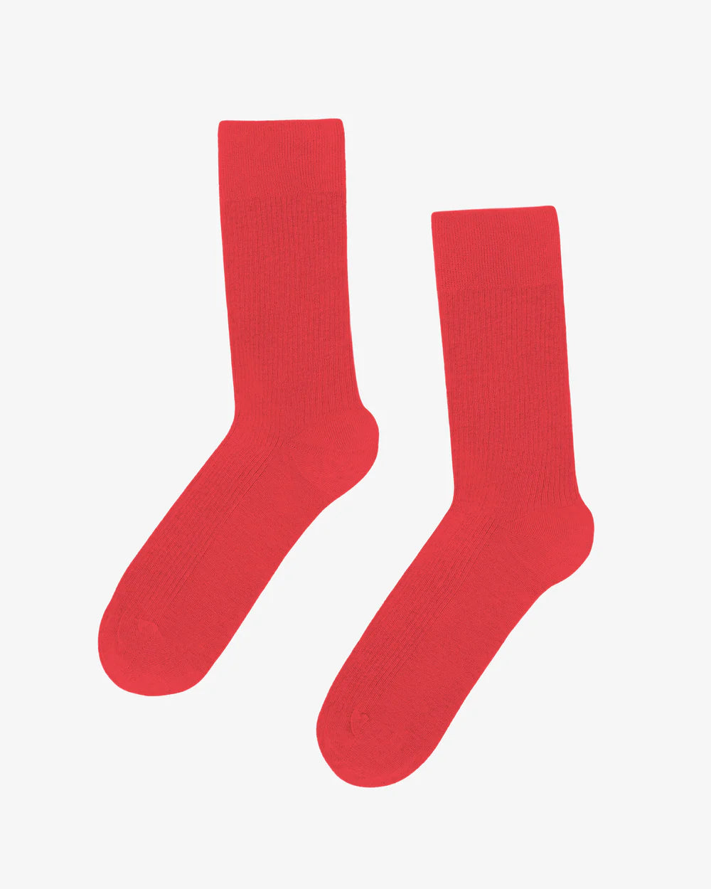 Two vibrant red Organic Active Socks by Colorful Standard, featuring an athletic fit, are showcased against a plain white background.