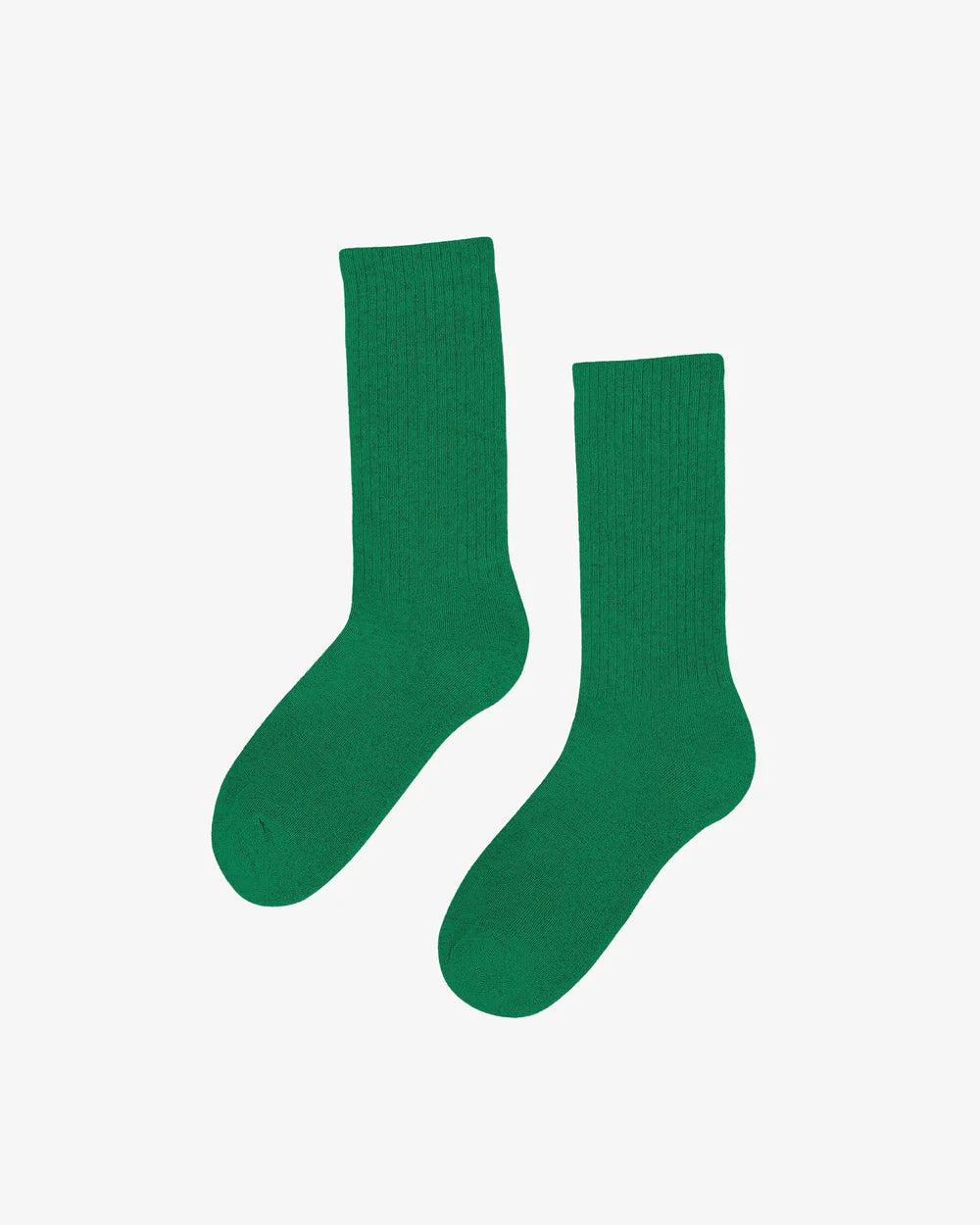 A pair of Colorful Standard Organic Active Socks in plain green, made from organic cotton, rests elegantly on a white background.