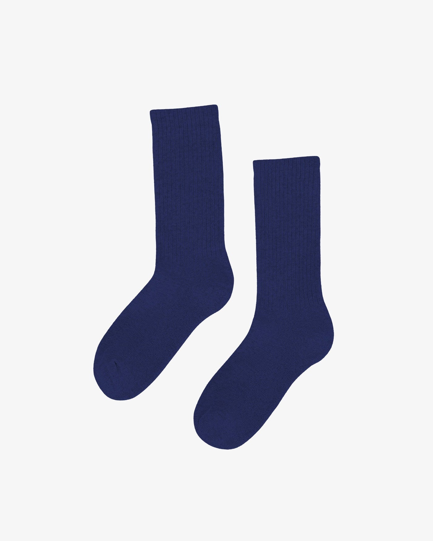 A pair of Organic Active Socks by Colorful Standard in plain, dark blue is displayed against a light background. Crafted from sustainable materials, they offer an athletic fit for ultimate comfort.